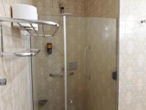 W łazience znajduje się prysznic ze szklanymi drzwiami. w obiekcie Hotel Pousada Oasis Park w mieście Jabuticabal