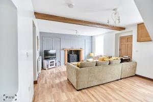 uma sala de estar com um sofá e uma televisão em Gwenallt em Dwyran