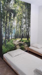 a bedroom with a painting of a forest at TERRASSES DE MALMEDY Triplex 259 " C EST LA VIE " in Malmedy