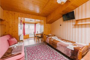 a bedroom with a bed and a couch and a tv at Wędrowiec in Karwia