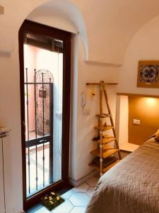 a room with a bed and a ladder and a window at A casa dei Sasso, Laetitia Suite in Positano