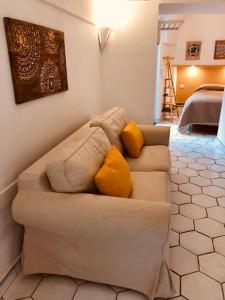 a couch with two yellow pillows in a living room at A casa dei Sasso, Laetitia Suite in Positano