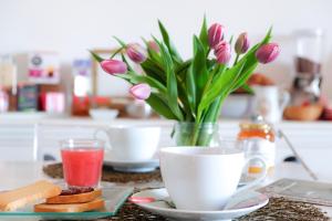 a table with a cup of coffee and a vase of flowers at ilmareinmezzo in Porto Recanati