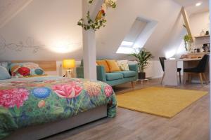 una camera con letto, divano e tavolo di Le Jardin des Roses a Saverne