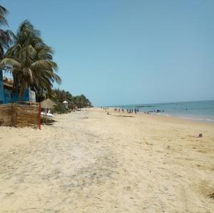 a beach with a lot of people and the ocean at Chez Coumba et Daniel in Saly Portudal