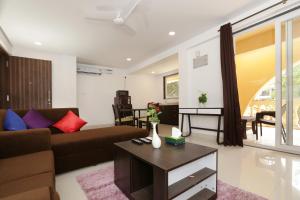a living room with a couch and a table at Goa Junction by Daystar Ventures in Anjuna