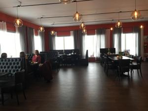a dining room with people sitting at tables and chairs at Lille Chili Guesthouse in Jakobselv