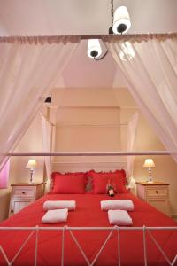 um quarto com uma cama vermelha com almofadas vermelhas em Sfakia Thea Apartments em Sfakiá