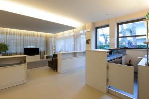 a large living room with white furniture and windows at Hotel Etruria in Forte dei Marmi