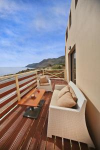 a deck with a couch and a table on a balcony at Sfakia Thea Apartments in Sfakia