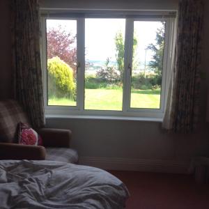 1 dormitorio con ventana y vistas al patio en Estuary View Farm en Kingsbridge