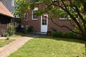 una casa de ladrillo con una puerta blanca y un patio en Ferienwohnung Kaiser Lothar, en Süpplingenburg