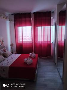 een slaapkamer met roze gordijnen en een bed met 2 zakken bij L'Angolo XXIV Maggio in Lecce
