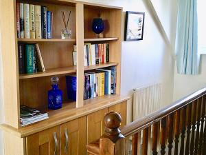 ein Bücherregal mit Büchern neben einer Treppe in der Unterkunft 24 Elmhurst Road in Lytham St Annes