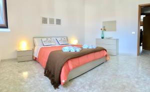 Un dormitorio con una cama con toallas azules. en Parco Adamantina di Fronte al Mare en Diamante