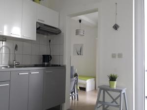 kuchnia z białymi szafkami, stołem i krzesłem w obiekcie Apartment Zea w Novalji