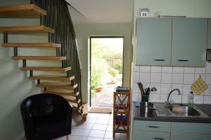 eine Küche mit Wendeltreppe und Spüle in der Unterkunft Ferienwohnungen Meyer in Bollewick