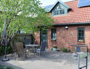 um pátio com cadeiras e uma mesa em frente a uma casa em Ferienwohnungen Meyer em Bollewick