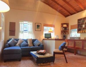 een woonkamer met een blauwe bank en een stoel bij Amanda's Place Casita Carinosa - pool and tropical garden in Caye Caulker