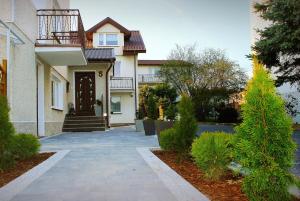 a house with a walkway in front of it at Pokoje Gościnne U RYBAKA in Karwia
