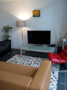 sala de estar con sofá y TV de pantalla plana en Jordaan Canal View Apartment en Ámsterdam