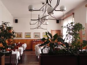 a dining room with tables and plants and a chandelier at Albergo Sant'Anna in Solbiate Olona