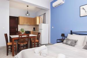 a room with two beds and a kitchen with a table at Aegean View Studio #1 in Azolimnos