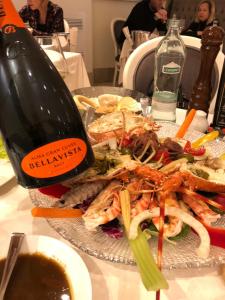 einen Teller mit Essen auf dem Tisch mit einer Flasche Wein in der Unterkunft Appartamento al mare Lorella in Sottomarina