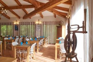 comedor con mesas y sillas de madera en Camping Les Oliviers en Porto Ota