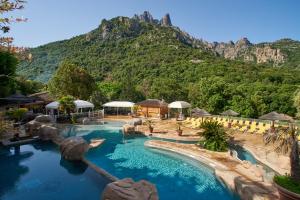 een resort met een zwembad met een berg op de achtergrond bij Camping Les Oliviers in Porto Ota