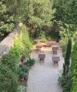 a garden with tables and benches and plants at Le Clos Saluces in Avignon