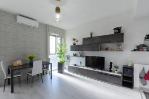 a living room with a dining table and a television at Appartamento moderno San Siro in Milan