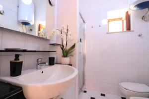 bagno bianco con lavandino e servizi igienici di Estate4home - SORRENTO HEARTS a Sorrento