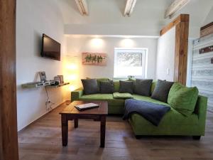 a living room with a green couch and a table at Doppelhaushälfte Nordwind vom Naturhof Usedom in Bannemin