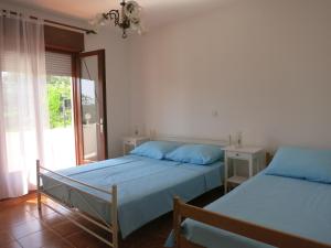 1 dormitorio con 2 camas y ventana en Apartments Mićo, en Rab