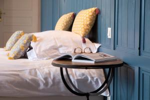 a table with a book and glasses on a bed at Domaine Utah Beach - Le Grand Hard in Sainte-Marie-du-Mont