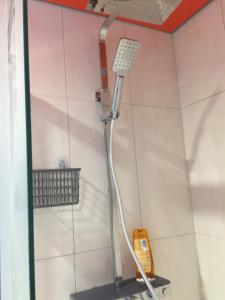 a shower with a shower head in a bathroom at Reiwa in Amsterdam