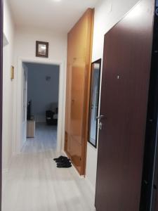 un pasillo con una puerta y un par de zapatos en el suelo en Apartman Gosto, en Mostar