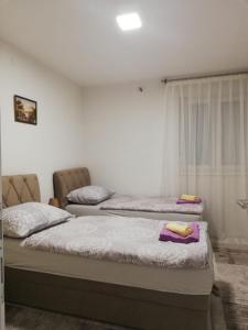 Dos camas sentadas en un dormitorio con toallas. en Apartman Gosto, en Mostar