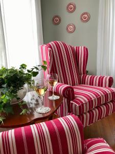 una sala de estar con una silla y una mesa con copas de vino en The Belmont Inn, en Camden