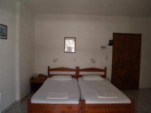 Habitación pequeña con 2 camas y ventana en Roses Studios, en Karpathos