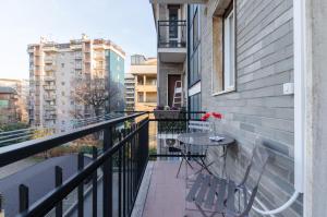 Appartamento moderno San Siro في ميلانو: بلكونه عليها طاوله وكراسي