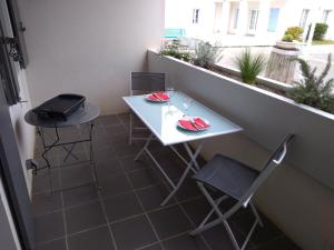 een witte tafel en 2 stoelen op een balkon bij Studio Carline in La Flotte