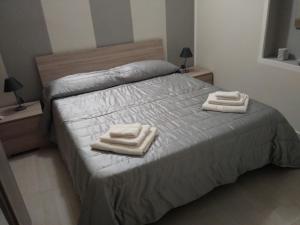 une chambre avec un lit avec deux serviettes dessus dans l'établissement Roma 12, à Messina 2 autres photos