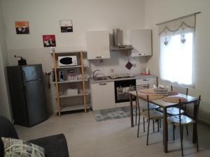 una piccola cucina con tavolo e frigorifero di Via Roma 12 a Messina