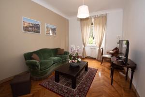 salon z zieloną kanapą i stołem w obiekcie Appartamento Luminoso con vista su Villa Ada w Rzymie