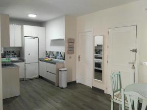 a kitchen with white cabinets and a table and chairs at Casa Playa Puerto Mazarrón in Puerto de Mazarrón