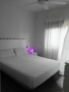Dormitorio blanco con cama grande y lámpara de color rosa en Casa Playa Puerto Mazarrón, en Puerto de Mazarrón 50 fotos más