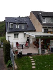 a white house with a patio with red chairs at Pension Haus Thies in Cochem