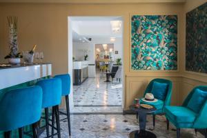 a lobby with blue chairs and a bar at Hotel Carlton in Beaulieu-sur-Mer